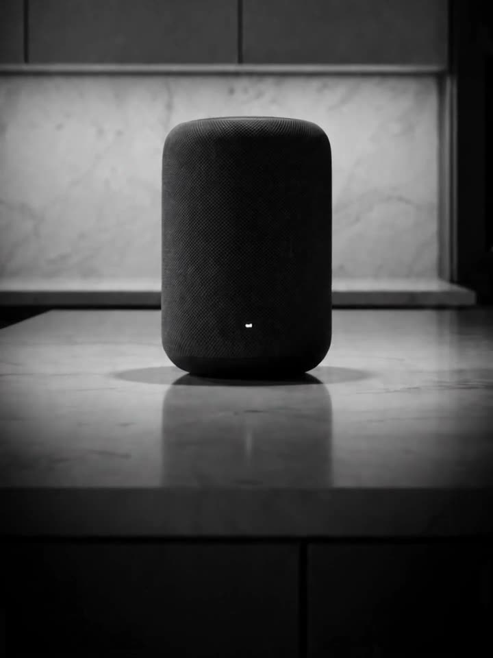 A dull gray smart speaker on a gray countertop